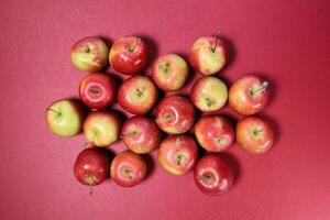 Small mini red apple on red background photo