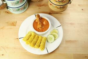 Traditional Malay snack food Roti Jala served with curry chicken with potato on white ceramic plate and bowl photo