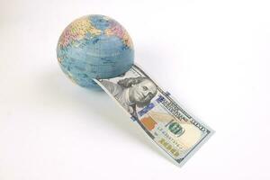 US Dollar currency paper money 100 Hundred dollar bill through planet earth globe on white background photo