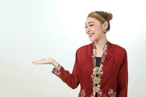 Asian woman traditional red maroon kebaya sharong on white background showing display look palm of hand photo