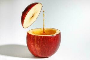 Red Apple real juice splash in fresh half cut hollow cup fruit photo