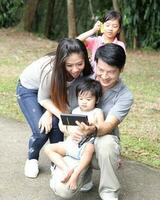 South East Asian young father mother daughter son parent boy girl child activity outdoors park photo