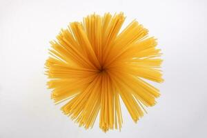 dry raw spaghetti white background blooming flower sunray glow pattern concept photo