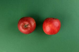 red apple on green colour paper background copy space for text photo