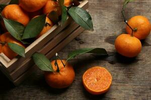 mandarin orange green leaf wood crate box on rustic wooden background photo