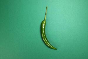 whole green chilli pepper on green background photo