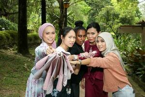 grupo de mujer malayo chino indio asiático al aire libre verde parque punto paraguas a cámara foto