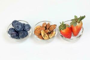 Blueberry Strawberry Herb Spice Almond Cashew Nut in glass bowl on white background photo