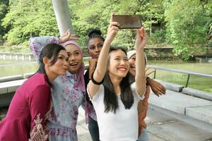 group of five woman Malay Chinese Indian Asian Malaysian outdoor green park lake nature selfie smartphone camera self portrait photo