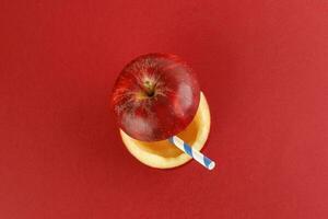 Health Red Cut Apple recyclable paper straw juice drink idea concept on red background photo