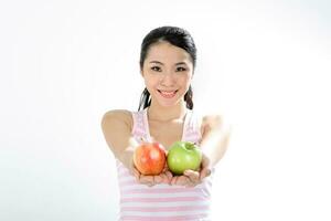 hermosa joven sur este asiático chino mujer participación sano verde y rojo manzana en blanco antecedentes foto