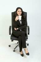 uno joven asiático malasio negocio mujer a oficina participación blanco sentar en silla bebida desde taza en blanco antecedentes foto