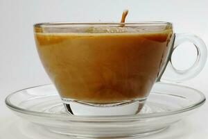 dark Coffee poring white milk dripping splash shadow liquid swirl in glass cup saucer on white background photo