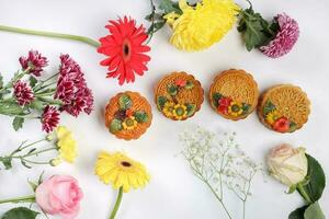 Colorful flower decorated moon cake Chinese mid autumn festival daisy chrysanthemum mum rose baby breath flower red yellow pink purple violet on white background photo