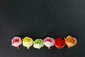 wafer edible paper biscuit rose flower cake decoration on black background red green pink yellow photo