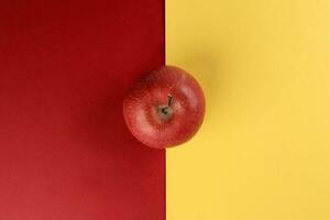 Red apple on yellow red colour paper background copy space for text photo