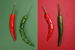 whole green red chilli pepper on green red paper background cut pieces seeds photo