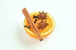 Fresh orange cinnamon star anise clove spice on white background photo