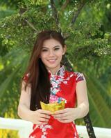 Young south east asian Chinese man woman traditional costume Chinese new year greeting outdoors at temple photo