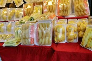 Fresh cut fruit wrapped in plastic selling at street market pomelo mango durian mango jackfruit photo