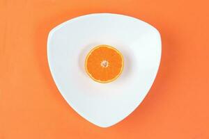 Mandarin Orange Fruit slice half juiced extracted on hart shape plate orange background photo