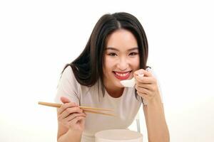 Beautiful young south east Asian woman holding chinese empty chopstick soup spoon bowl utensil pretend acting posing see eat taste feed offer satisfaction yummy white background happy photo