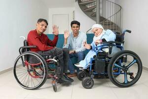 Portrait of young man and woman talking discussing work business. Two on wheelchair are paralyzed and one sitting on sofa adhd also Autism autistic photo