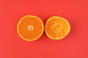 Mandarin Orange Fruit slice half juiced extracted on red background photo