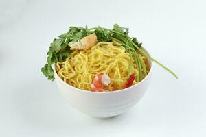 Fresh yellow egg noodle prawn tofu coriander leaf in bowl on whit background photo