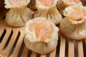 Prawn shrimp shaomai dim sum dumpling in bamboo steamer on white background photo