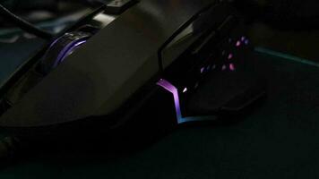 a black gaming mouse with twinkling lights. Special gaming mice have special buttons to make it easier when playing games. video