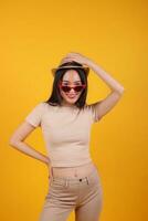 hermosa joven sur este asiático mujer rojo marco gafas de sol sombrero actitud Moda pico contento en amarillo naranja antecedentes foto