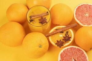 Fresco naranja canela estrella anís Clavo especia jugo en vaso en blanco amarillo antecedentes foto