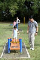 South East Asian young Chinese father mother daughter son parent child play relax activity outdoor park photo