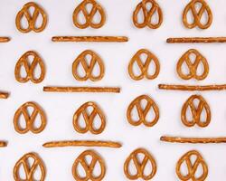 Pretzel cracker sticks laid in rows design angle straight on what background photo