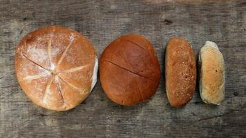 Freshly baked bread loaf bun roll round long mix verity on wooden over rustic wooden background photo