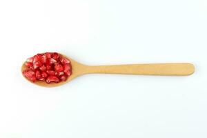 Red Pomegranate seed wooden spoon white background photo