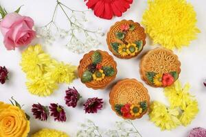 Colorful flower decorated moon cake Chinese mid autumn festival daisy chrysanthemum mum rose baby breath flower red yellow pink purple violet on white background photo