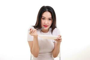 Beautiful young south east Asian woman pretend acting posing holding empty fork spoon in hand eat taste look see white plate on table white background photo