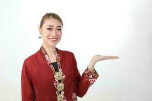 Asian woman traditional red maroon kebaya sharong on white background showing display hand palm photo