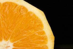 Yellow juicy orange closeup macro pulp on black background photo