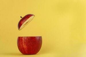 Healthy Red Cut Apple floating top slice juice drink idea concept on yellow background photo