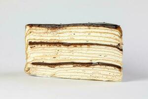 Chocolate crepe layer cake slice white background photo