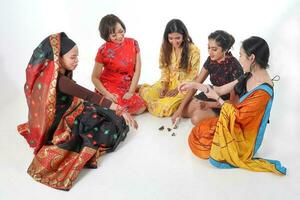 South east Asian Malay Chinese Indian race ethnic origin woman wearing dress costume baju kurung cheongsam samfu kebaya Sharee multiracial community playing Batik Batu Seremban on white background photo