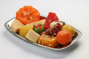 Colourful variety of Indian sweet desert jilepi jilapi amriti halva sondesh barfi laddu on silver tray traditional festival photo