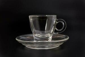 vacío transparente vaso ver mediante café té taza platillo en negro antecedentes foto