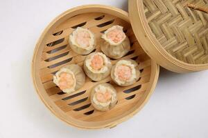 Prawn shrimp shaomai dim sum dumpling in bamboo steamer on white background photo