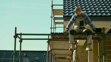 construcción trabajador relajante en un andamio. industrial tema. video