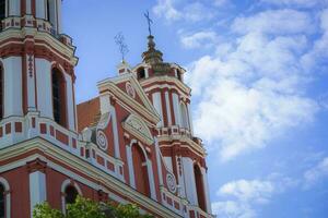 The roof top and part of a facade of the St. Apostles Philip and Jacob Church on blue sky with white clouds background photo