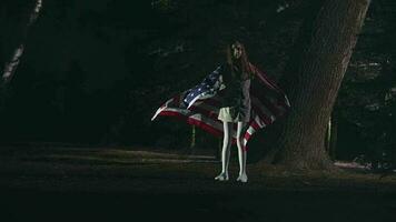 Night Scene At Park With Cute Girl Standing With Open Arms Holding And Waving American Flag. video